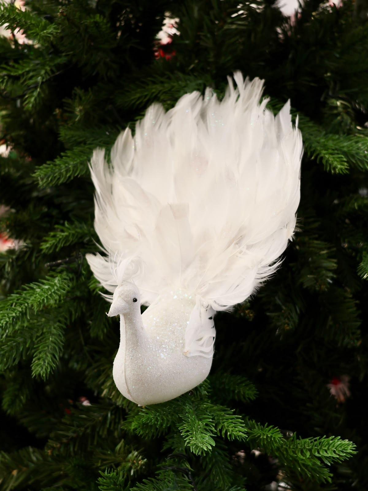 WhatsApp Image 2026-07-25 at 4.55.51 PM Bring graceful elegance to your Christmas décor with this handcrafted white feather bird ornament. Featuring soft layered feathers and a long flowing tail, it adds movement, texture, and a luxurious touch to your Christmas tree, wreaths, garlands, or festive centerpieces. Its lightweight clip design makes decorating easy while creating a timeless winter look. Features * Handcrafted decorative feather bird * Soft white layered feathers with a long elegant tail * Easy clip attachment for secure placement * Perfect for Christmas trees, wreaths, garlands, and centerpieces * Designed to complement both classic and modern holiday décor