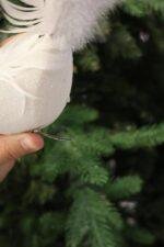 Bring graceful elegance to your Christmas décor with this handcrafted white feather bird ornament. Featuring soft layered feathers and a long flowing tail, it adds movement, texture, and a luxurious touch to your Christmas tree, wreaths, garlands, or festive centerpieces. Its lightweight clip design makes decorating easy while creating a timeless winter look. Features * Handcrafted decorative feather bird * Soft white layered feathers with a long elegant tail * Easy clip attachment for secure placement * Perfect for Christmas trees, wreaths, garlands, and centerpieces * Designed to complement both classic and modern holiday décor